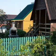 Ogródek z domkami, grillem i huśtawką. Czy myśliwy może strzelać w kierunku budynku? Nie, to niebezpieczne.