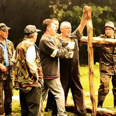 Grupa mężczyzn w strojach myśliwskich buduje drewnianą konstrukcję. Czy myśliwy ma obowiązek wykonać prace na rzecz koła?