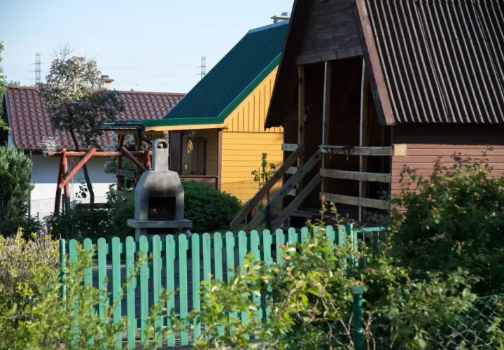 Ogródek z domkami, grillem i huśtawką. Czy myśliwy może strzelać w kierunku budynku? Nie, to niebezpieczne.