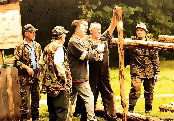 Grupa mężczyzn w strojach myśliwskich buduje drewnianą konstrukcję. Czy myśliwy ma obowiązek wykonać prace na rzecz koła?